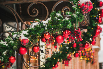 Building front decorated to Christmas with christmas trees fir branches, decorations and garland lights - festive and winter holidays concept