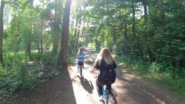 A pathway along Rhein River, where people ride their bikes over the bike lane and take a walk over the sidewalk together