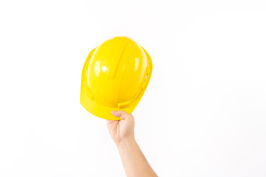 The man hand holding Yellow safety helmet or hard hat isolated on white background.