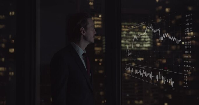 Businessman Trader Working Late in office Looking at Stock Market Data