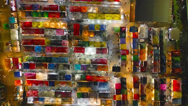 Aerial top view of Night Market people walking street, Colorful tents in the train of Ratchada at Bangkok city, Thailand. Retail shops