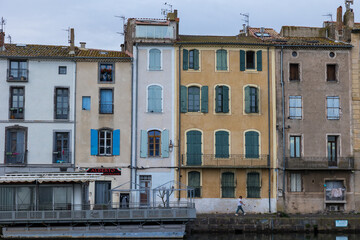 Fototapeta na wymiar Façade des immeubles et maisons au bord du fleuve Hérault dans le centre historique d'Agde