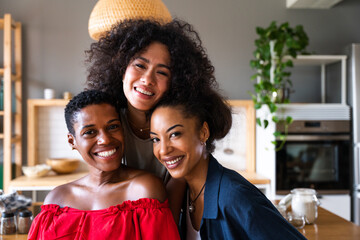Three mixed race hispanic and black women bonding at home - Multiracial group of happy young female...