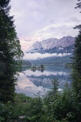 Vertical shot of the lake Eibsee reflecting mountains and a cloudy sky, Bavaria, Germany