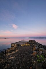 Vertical shot of a beautiful pink sunset reflecting on the surface of a lake, Hofn, Iceland