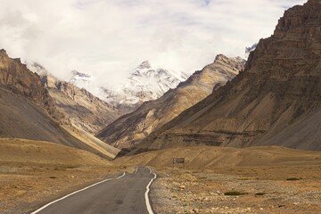 Aerial view of road surrounded by greenery fields in background of mountains