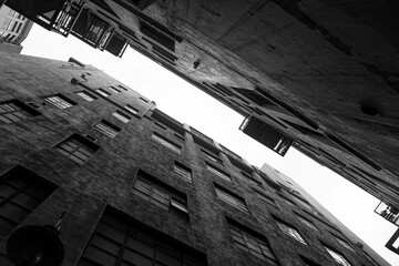 Obraz premium Low angle view of stony buildings in black and white