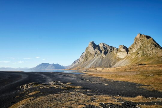 Beautiful view of Hvalnes beach with black sand and rocks in Iceland.
