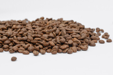 Fragrant and roasted coffee beans on a white background, place for inscription and advertising.