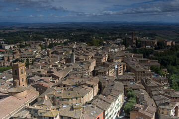 Fototapeta na wymiar Scenery of Siena, a beautiful medieval town in Tuscany, landmark Mangia Tower and Basilica of San Domenico, Italy