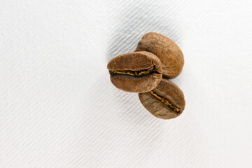 three roasted coffee beans macro, energy drink grains.