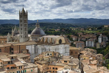Fototapeta na wymiar Scenery of Siena, a beautiful medieval town in Tuscany, with view of the Dome & Bell Tower of Siena Cathedral (Duomo di Siena), landmark Mangia Tower and Basilica of San Domenico, Italy