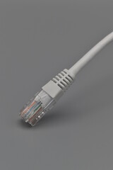 The end of a white ethernet cable on a gray background