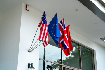 Obraz premium The US, EU, UK, and Moroccan flags hanging on the entrance of a luxury hotel