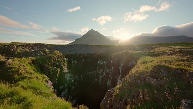Sunset over Stapafell mountain and seagull nest hole on coastline in Arnarstapi village on summer at Iceland