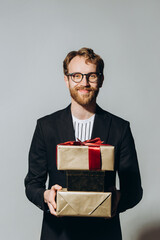 Celebration Time. Portrait of a happy guy holding stack of present boxes isolated over white background at studio.