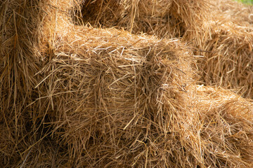 Straw bales are stacked on top of each other.