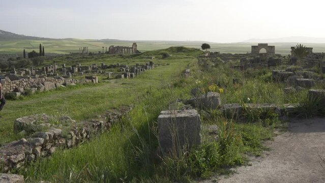 Man passing by Volubilis ruins. Berber-Roman city in Morocco situated near the city of Meknes.