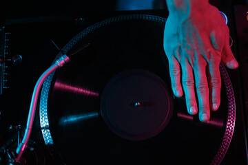 Hip hop dj scratching vinyl record on party in night club. Overhead stock photo of turntable on...