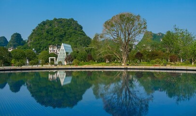 Tree and house reflected on the water lake