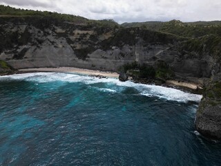 Fototapeta premium Vertical bird's eye view of a seacoast surrounded by cliffs