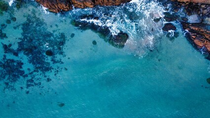 Aerial shot of beautiful coastline with light blue ocean water