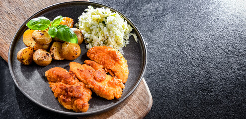 Breaded chicken cutlets served with potatoes and cabbage