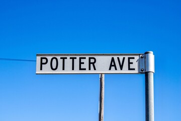 Closeup shot of a Potter Avenue street sign against a blue sky background at Emmaville, Australia - Powered by Adobe