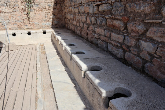 Ancient public Toilet bathroom seats on Ephesus made of rocks, bricks, granite and marble