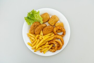 Top view of french fries with chicken nuggets and onion rings isolated on white background