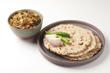 indian village food, Jowar Roti or Indian bread, served with roasted eggplant/brinjal curry ,green chilli thecha OR Chutney