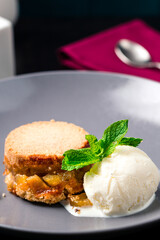 apple pie on plate with a scoop of vanilla ice cream