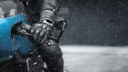 Hand in glove on motorcycle handlebar in winter, free space for insertion