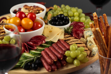 A well-curated selection of fine cheeses and charcuterie elegantly arranged on a wooden platter, ready to be the centerpiece of any festive occasion