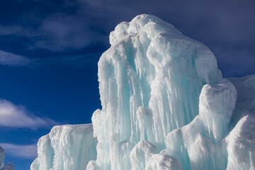 Fototapeta premium Frozen geyser forming a majestic ice sculpture against the blue sky