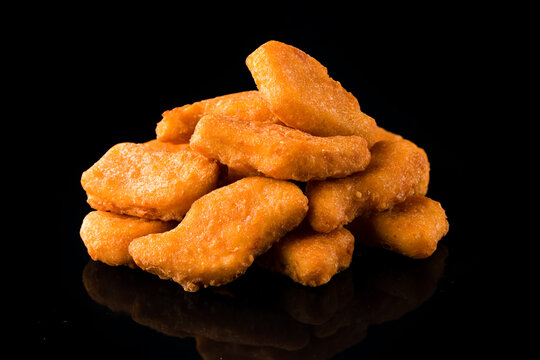A pile of chicken nuggets isolated on black background