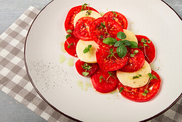 Caprese salad, Italian traditional dish, tomatoes with mozzarella cheese, basil and spices, top view, no people,
