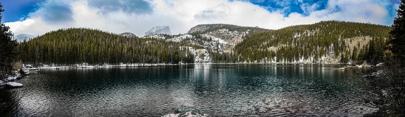 Obraz premium Panoramic view of Bear Lake surrounded by mountains covered with pine forest and snow in winter