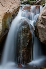 Long exposure shot of a small waterfall full of rocks in the daylight