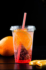 cocktail with orange in the plastic cup