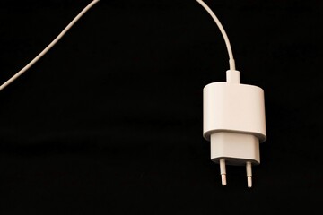 White european plug fast charger block connected to cable isolated on black background. 20W USB-C...
