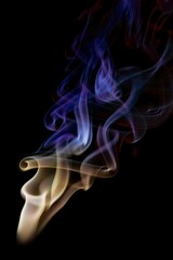 Beautiful shot of a colorful cone incense smoke trails isolated on black background