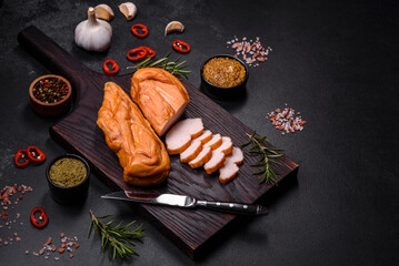 Tasty smoked fillet of chicken breast with spices and herbs on a wooden cutting board