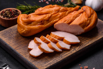 Tasty smoked fillet of chicken breast with spices and herbs on a wooden cutting board
