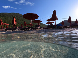 Underwater split photo of famous organised beach of Antisamos in island of Kefalonia with crystal...