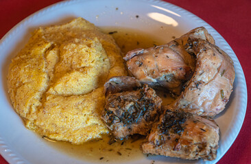 rabbit meat with polenta. local corn porridge with stew pieces of rabbit. Selective focus with shallow depth of field. Traditional italian cuisine.