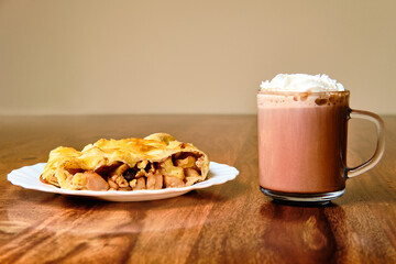 Apple strudel with cocoa drink on table