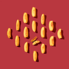 Creative pattern made with fresh peaches slice on dark red background. Minimal summer fruit arrangement.