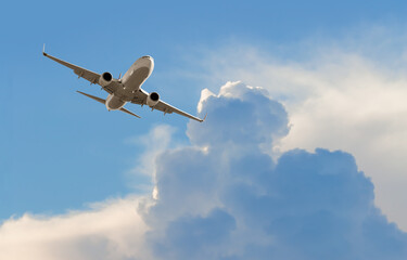 White passenger airplane flying in the sky amazing clouds in the background - Travel by air transport