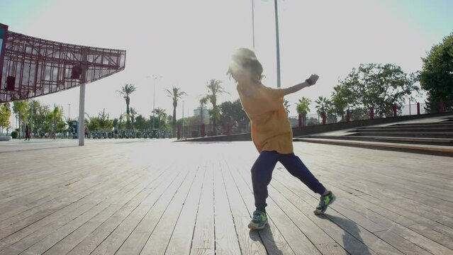 dancing child. dancing break-dance on the street rhythmically waving his arms. hip hop dancer practicing dance routine doing freestyle moves in the city